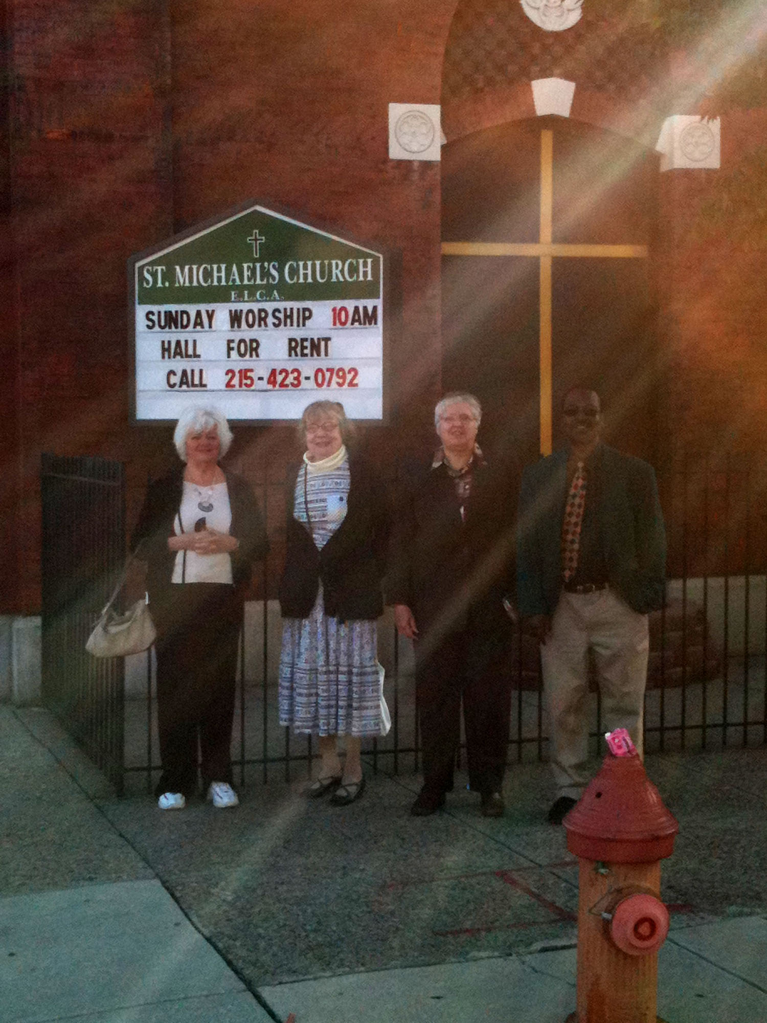 God's light filtered through the city scape as the Redeemer Ambassadors pose in front of St. Michael's, Kensington.